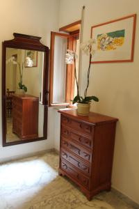 - une commode avec un miroir et une plante dans l'établissement Residence Balduina, à Rome