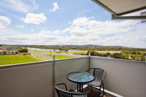 a balcony with a table and chairs and a view of a street at Four Kings 3 in Anglesea