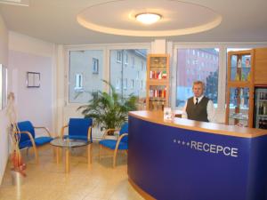 a man sitting at a counter in a room at Hotel Steiger in Krnov