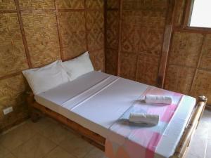 a bed in a room with two towels on it at Isla Hayahay Beach Resort and Restaurant in Calape