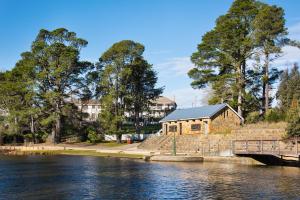 a wooden building next to a river with a bridge at Lake Daylesford Apartments 7 in Daylesford