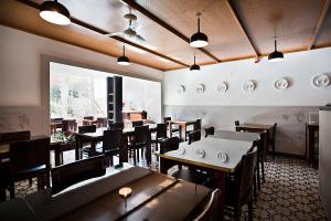 Un restaurante con mesas y sillas y un gran ventanal. en Pensao Favorita, en Oporto