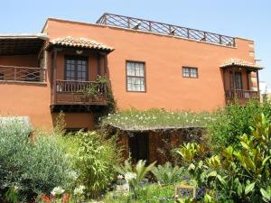 een oranje huis met ramen en planten in de tuin bij Hotel Rural San Miguel - Only Adults in San Miguel de Abona