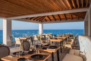 a dining room with chairs, tables, and chairs at Abaton Island Resort & Spa in Hersonissos