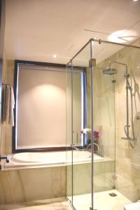 La salle de bains est pourvue d'une douche avec une porte en verre. dans l'établissement Signature Boutique Hotel, à Hô-Chi-Minh-Ville
