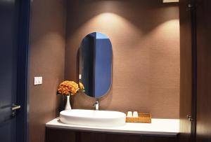 La salle de bains est pourvue d'un lavabo et d'un miroir. dans l'établissement Signature Boutique Hotel, à Hô-Chi-Minh-Ville
