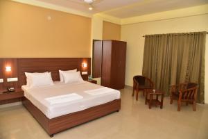 a bedroom with a bed and a table and chairs at Hotel Citywalk Residency in Mangalore