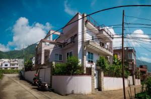 a white house on a street with mountains in the background at Sweet Dream Apartment in Kathmandu