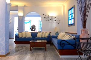 a living room with a blue couch and a table at Atlantis Beach Villa in Perivolos