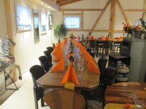 ein langer Tisch in einem Raum mit orangefarbenen Papierbooten darauf in der Unterkunft Eichhof Brienzwiler Berner Oberland in Brienzwiler