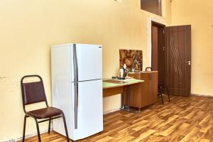 a refrigerator in a kitchen with a desk and a chair at GoriHouse in Gori
