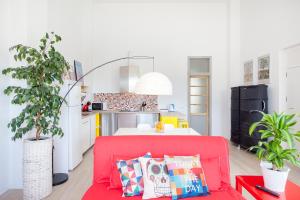 a living room with a red couch and a kitchen at Atico Valencia Sorolla in Valencia