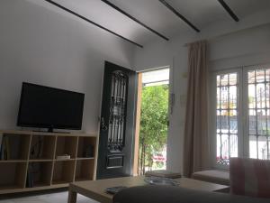 Apartamento con Patio في مالقة: غرفة معيشة مع تلفزيون ونافذة