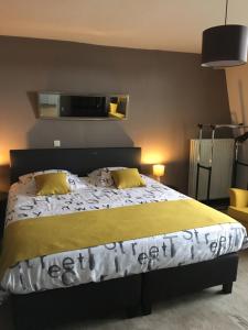 a bedroom with a large bed with yellow pillows at Le Grand Cabaret in Nieuwpoort
