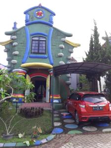 a red car parked in front of a house at Villa Kota Bunga NA2 in Puncak