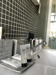 a bathroom sink with two tubes of sunscreen on it at Le Grand Cabaret in Nieuwpoort +24 photos