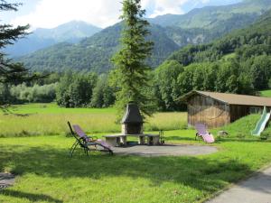 2 Stühle und ein Picknicktisch auf einem Feld in der Unterkunft Eichhof Brienzwiler Berner Oberland in Brienzwiler