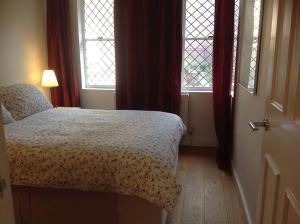 a bedroom with a bed and two windows at Farriers House in London