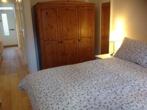 ロンドンにあるFarriers Houseのベッドルーム1室(ベッド1台付)、木製キャビネットが備わります。