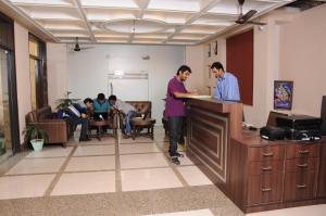 a man standing at a counter in an office at Hotel Diamond Inn in Chandīgarh
