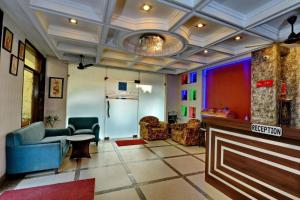 a living room with blue chairs and a kitchen at Hotel Diamond Inn in Chandīgarh
