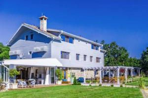 ein großes weißes Haus mit einem Rasen davor in der Unterkunft St Anastasia Hotel in Burgas City