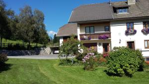 a house with flowers in front of a yard at Haus Pfarrkirchner in Mauterndorf