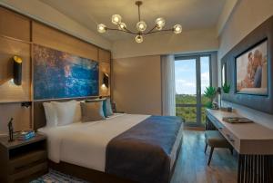 um quarto de hotel com uma cama, uma secretária e uma janela em Somerset Maslak Istanbul em Istambul