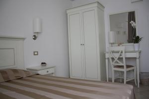 Habitación blanca con cama y escritorio en Alla Corte Del Picchio Room & Breakfast en Castel Guelfo di Bologna