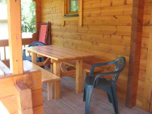 a wooden table and chairs on the porch of a cabin at La Simonette in Dienville
