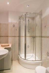 La salle de bains est pourvue d'une douche et d'un lavabo. dans l'établissement Apartament Rozbrat, à Varsovie