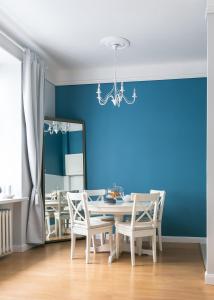 comedor con mesa, sillas y espejo en Apartament Rozbrat en Varsovia