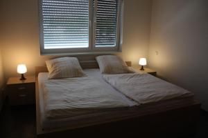 a bedroom with two beds and two lamps on tables at Hotel Grand Tour in Wesseling