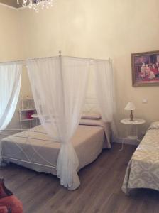 1 dormitorio con cama con dosel y cortinas en Residenza d'Aste, en Albenga