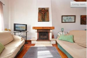 a living room with two couches and a fireplace at By the sea in the center @ Ericeira in Ericeira