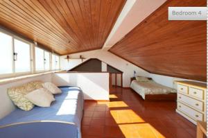 Un dormitorio con una cama y un techo de madera. en By the sea in the center @ Ericeira, en Ericeira