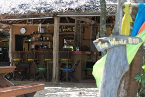 a restaurant with a bar with chairs and tables at Melina Beach Front Bungalows in Tha Lane Bay