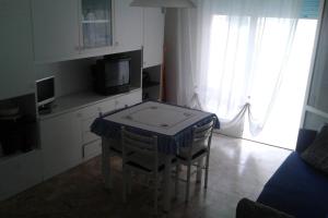 una cucina con tavolo, sedie e TV di Appartamento Centromare solo famiglie a Lido di Jesolo