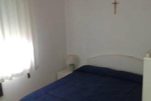 una camera con un letto blu e una croce sul muro di Appartamento Centromare solo famiglie a Lido di Jesolo