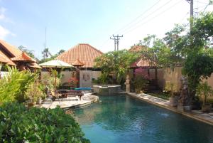 a swimming pool in a yard with a fountain at Wikarmas Villa Sanur in Sanur