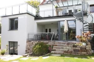 Biały dom z balkonem i patio w obiekcie FAMOS Schlafen w mieście Warburg