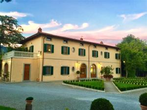 una grande casa bianca con molte finestre di La Cantina Relais - Fattoria Il Cipresso ad Arezzo