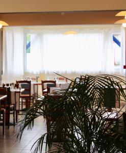 un comedor con mesas, sillas y una planta en Kyriad Bourges Sud, en Bourges