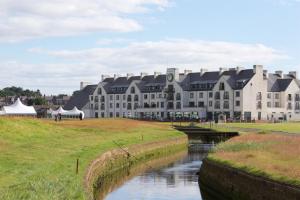 a large building with a river in front of it at Carnoustie Golf Hotel 'A Bespoke Hotel’ in Carnoustie
