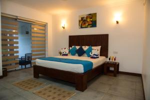 
a bedroom with a bed and a dresser at Anantamaa Hotel in Trincomalee
