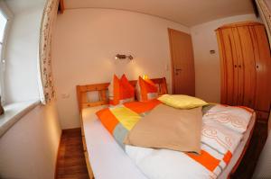 a bedroom with a large bed with orange and yellow pillows at Bauernhof Gfraser in Serfaus