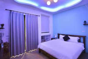 a bedroom with a white bed and a blue ceiling at And B&B in Hengchun