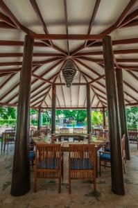 een grote tent met houten tafels en stoelen bij Anantamaa Hotel in Trincomalee