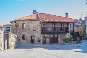 a large stone house with a balcony on top of it at Casaquina in La Mezquita