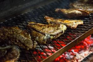 a bunch of meat cooking on a grill at A-1 Njalo-NjaloSafari´s in Touwsrivier